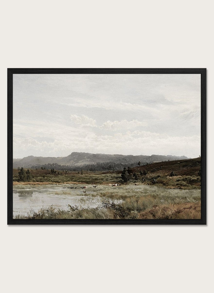 A framed landscape art print depicting a muted, overcast valley scene with a small body of water, grassy foreground, distant hills, and a cloudy sky, shown against a light neutral background. A View of Fleet Moor, Surrey by Alfred de Bréanski is a vintage English landscape print featuring cattle, water, rolling hills, open countryside, and a cloudy sky.
