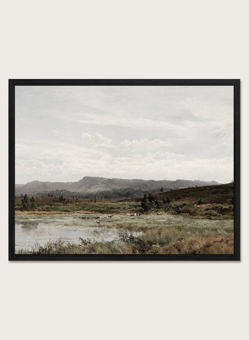 A framed landscape art print depicting a muted, overcast valley scene with a small body of water, grassy foreground, distant hills, and a cloudy sky, shown against a light neutral background. A View of Fleet Moor, Surrey by Alfred de Bréanski is a vintage English landscape print featuring cattle, water, rolling hills, open countryside, and a cloudy sky.