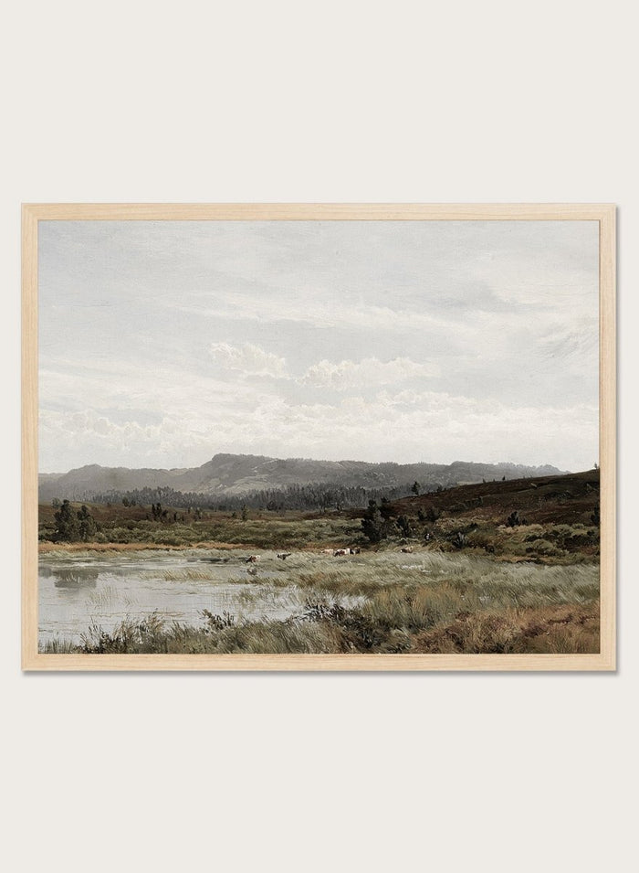 A framed landscape art print depicting a muted, overcast valley scene with a small body of water, grassy foreground, distant hills, and a cloudy sky, shown against a light neutral background. A View of Fleet Moor, Surrey by Alfred de Bréanski is a vintage English landscape print featuring cattle, water, rolling hills, open countryside, and a cloudy sky.