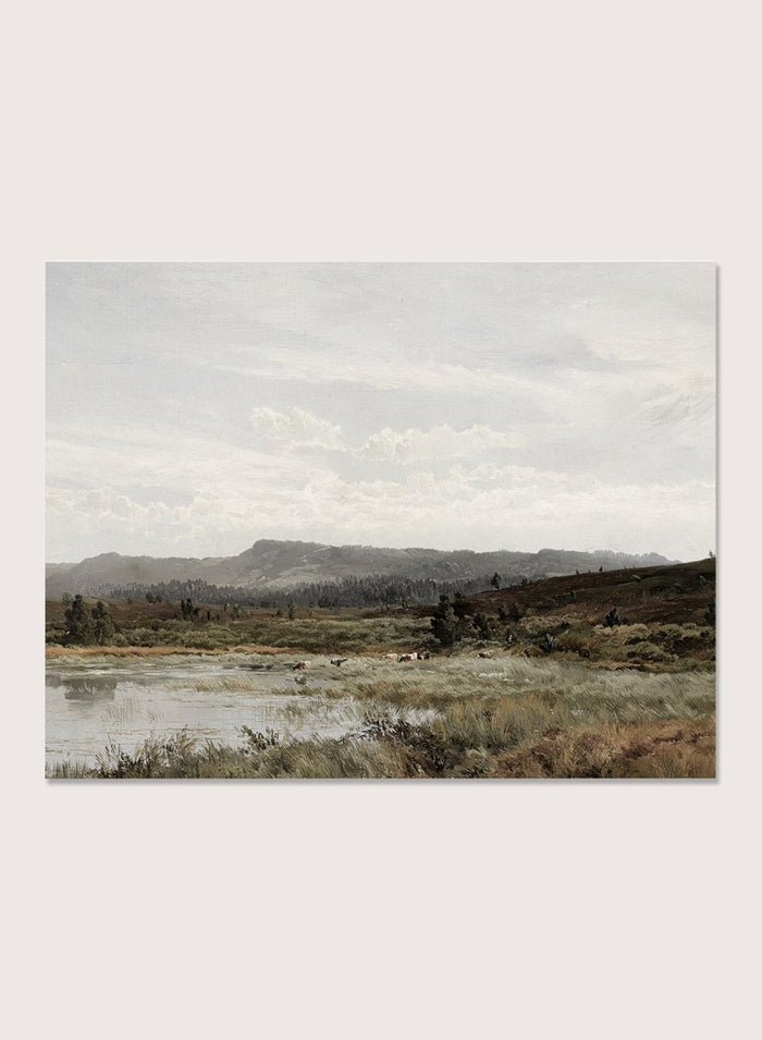 A framed landscape art print depicting a muted, overcast valley scene with a small body of water, grassy foreground, distant hills, and a cloudy sky, shown against a light neutral background. A View of Fleet Moor, Surrey by Alfred de Bréanski is a vintage English landscape print featuring cattle, water, rolling hills, open countryside, and a cloudy sky.