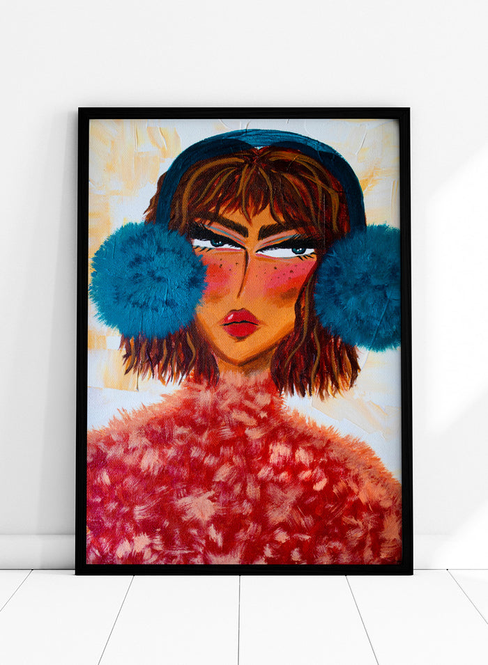 A stylized portrait painting of a woman with brown hair, a dark blue head covering, large bright blue pom-pom ear muffs, and a textured red fuzzy garment, set against a warm cream background. Shop Sassy Earmuffs Portrait by Amy Straley, a contemporary figurative wall art print featuring a bold woman portrait, blue earmuffs, and vivid pink and red tones.