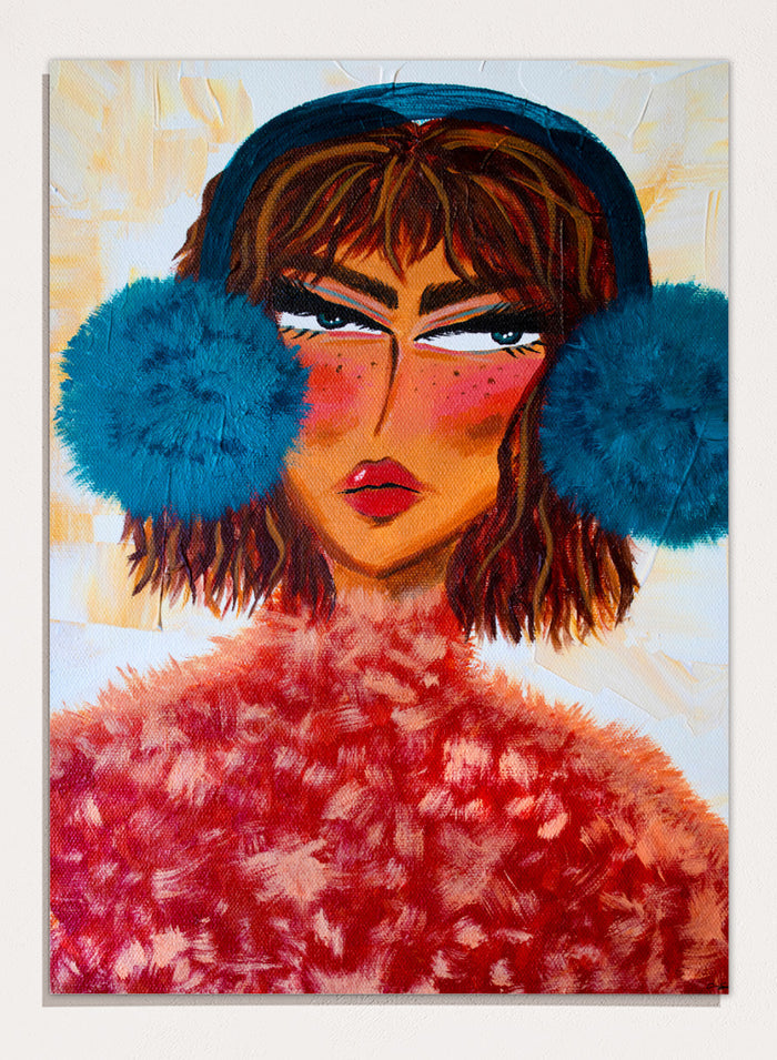 A stylized portrait painting of a woman with brown hair, a dark blue head covering, large bright blue pom-pom ear muffs, and a textured red fuzzy garment, set against a warm cream background. Shop Sassy Earmuffs Portrait by Amy Straley, a contemporary figurative wall art print featuring a bold woman portrait, blue earmuffs, and vivid pink and red tones.