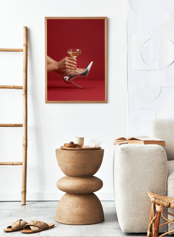 High-heeled shoe holding a glass of white wine against a red background, High Heels and Champagne by Andreas Magnusson is a fashion illustration art print featuring high heels, champagne glass imagery, bold red tones, and modern contemporary wall art style.