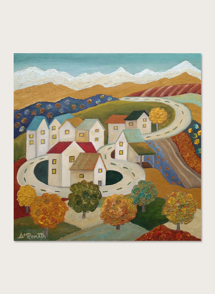 A framed folk-art style landscape painting depicting a village with white houses, winding roads, colorful trees, and mountains under a blue sky. Shop Autumn Road Village by Angeles M. Pomata, a colorful autumn landscape art print featuring a winding road, white village houses, fall trees, and distant mountains.