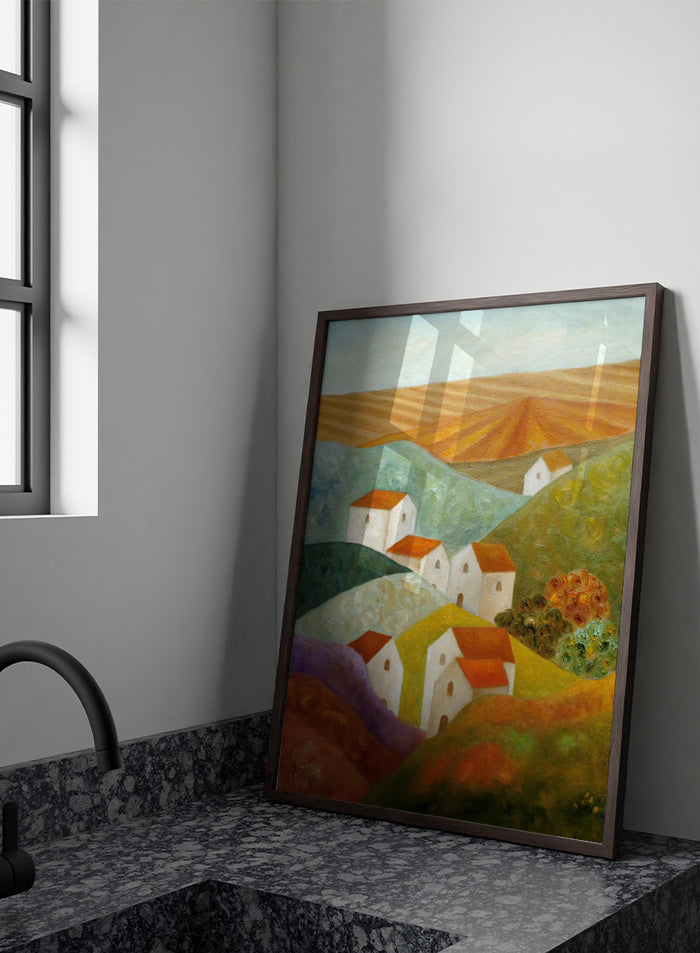 A colorful landscape painting featuring white houses with orange-red roofs nestled among rolling hills in shades of green, purple, yellow, and orange, with a plowed field under a pale sky in the background. Shop Colorful Hillside Village by Angeles M. Pomata, an autumn countryside art print featuring white houses, rolling hills, warm fields, and earthy color.