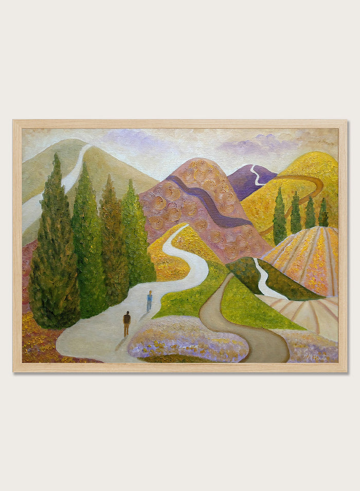 A framed landscape painting featuring stylized mountains, evergreen trees, winding paths, and small human figures, shown against a light neutral background. Shop Peaceful Journey Through Hills by Angeles M. Pomata, an autumn landscape art print featuring winding roads, cypress trees, rolling hills, and two walking figures.
