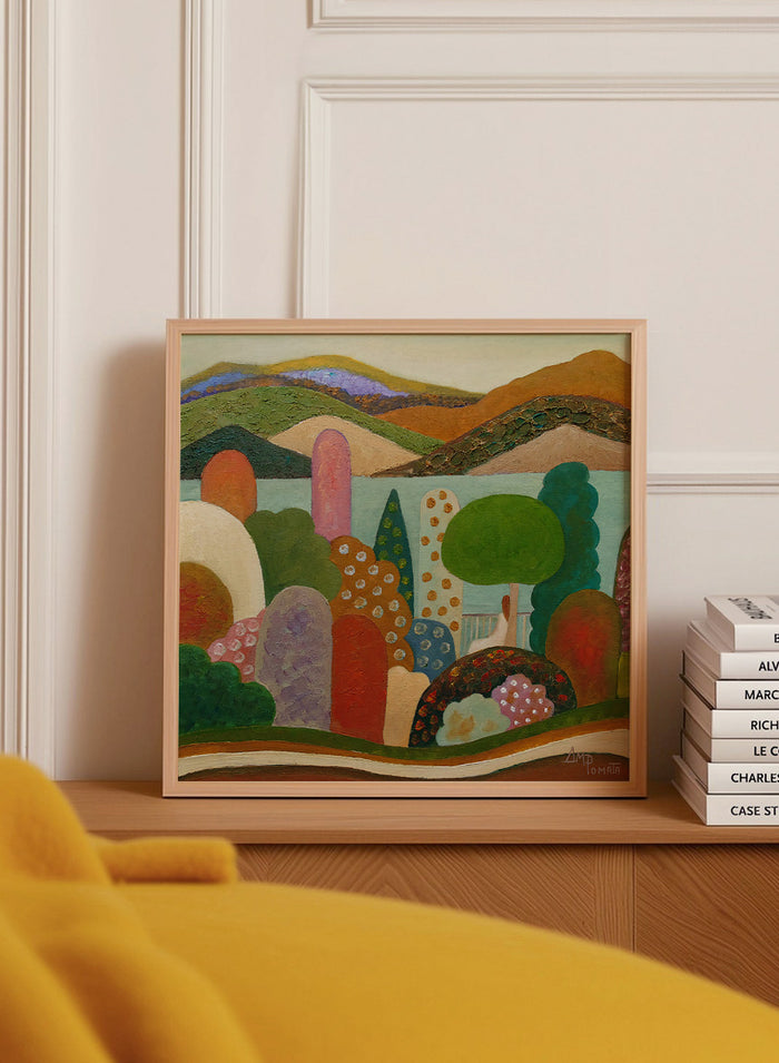 A framed landscape painting featuring stylized hills, trees, and abstract shapes in earthy tones of green, brown, orange, red, blue, and purple. Shop Vibrant Whimsical Landscape by Angeles M. Pomata, a colorful landscape art print with layered hills, patterned trees, and a soft dreamlike feel.