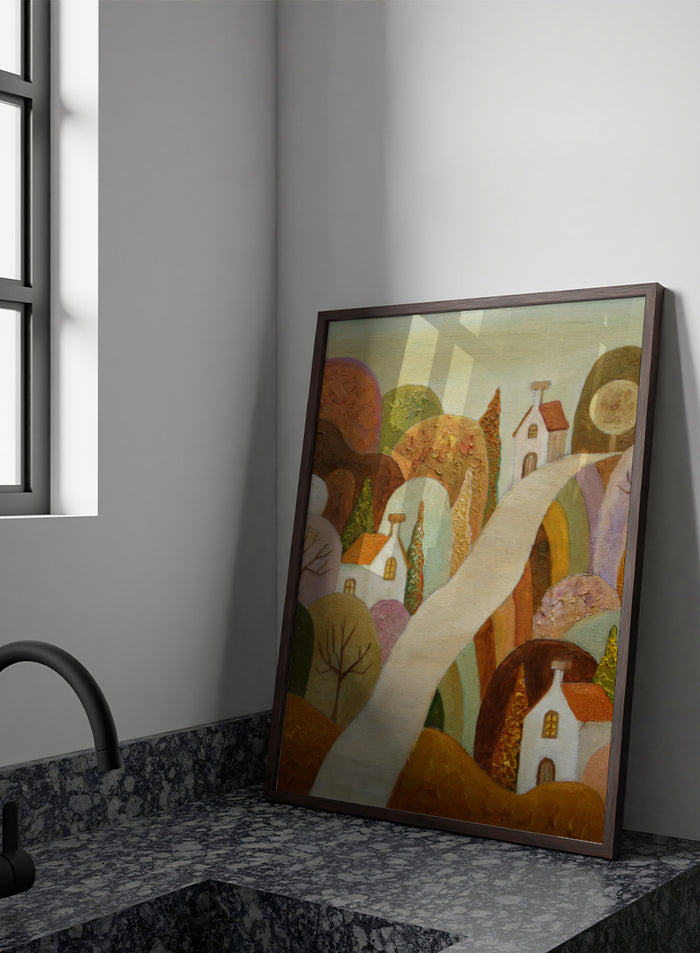 A stylized landscape painting featuring small white houses with orange roofs, rolling hills in earthy tones, and a pale winding path through the scene. Shop Whimsical Village Path by Angeles M. Pomata, an autumn landscape art print featuring a winding road, white village houses, rounded hills, and warm earthy tones.
