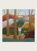 A framed landscape painting featuring a woman standing among tall trees, looking over a patchwork field of hills in earthy tones of green, purple, orange, and beige. Shop Woman Among Vibrant Hills by Angeles M. Pomata, a colorful landscape and portrait art print featuring a woman, rolling hills, trees, and earthy tones.