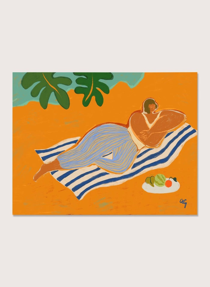 Framed artwork of a woman lounging on a towel with a plate of fruit against an orange background. A Day at the Beach by Arty Guava is a colorful coastal art print featuring a relaxed beach scene, tropical foliage, bold color, and contemporary illustration.
