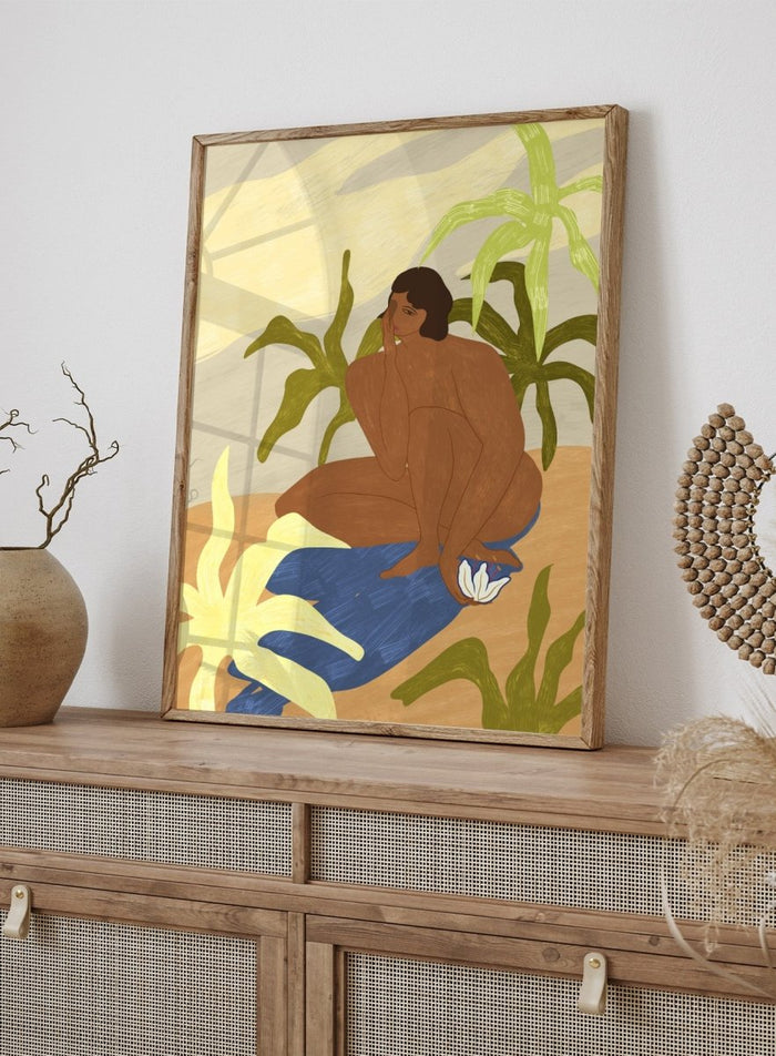 An art print featuring a stylized illustration of a seated figure with dark hair, surrounded by green tropical leaves, a blue cloth, and a white flower, set against a sandy beige and cream background. Au Naturel by Arty Guava premium framed fine art print featuring a seated woman surrounded by oversized tropical plants in warm earthy tones.