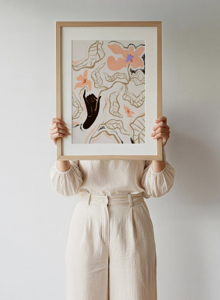 Abstract artwork with a black hand reaching towards flowers on a light background. Fleur by Arty Guava is a modern floral art print with soft abstract flowers and hand-drawn linework. Officially licensed wall poster with framing.