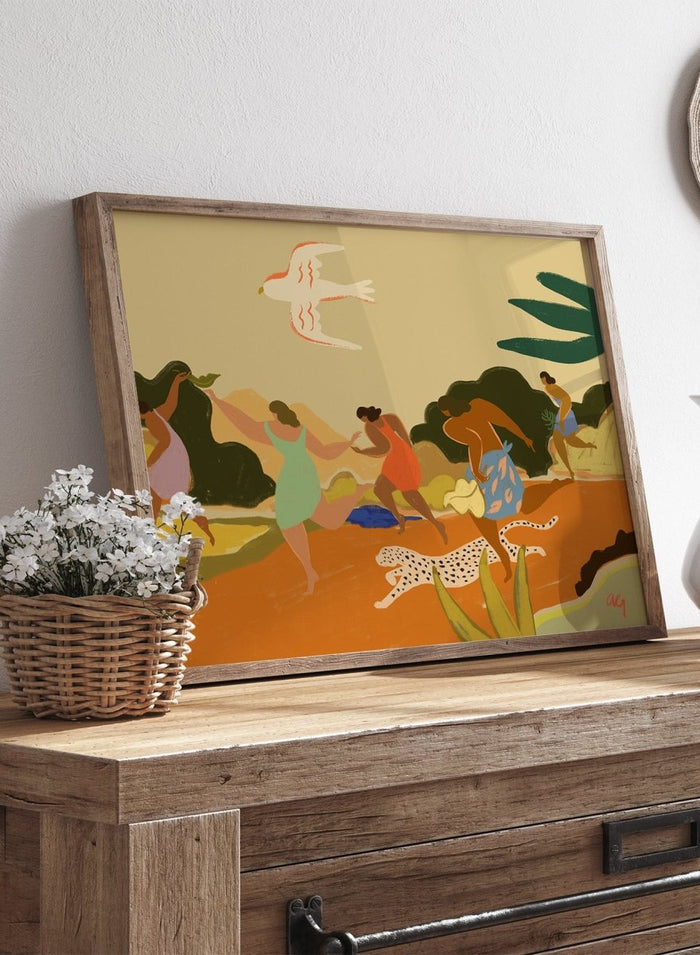 A framed art print featuring a stylized illustration of figures dancing and playing outdoors, with a bird, palm leaves, and a spotted cat. Run by Arty Guava premium framed fine art print featuring women racing through a tropical landscape beside a spotted leopard in warm, playful colors.