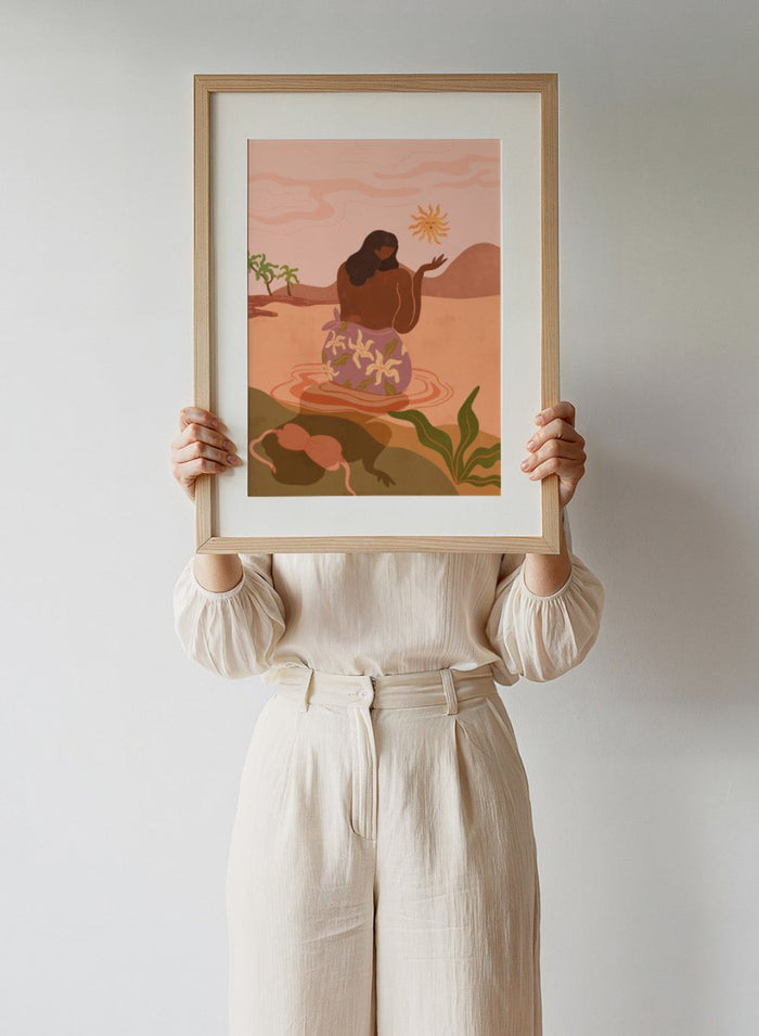 Illustration of a woman in a floral dress sitting by a pool with a sun and desert landscape in the background. Sunset by Arty Guava art print, modern woman illustration wall poster in warm pink tones, contemporary nature landscape artwork.