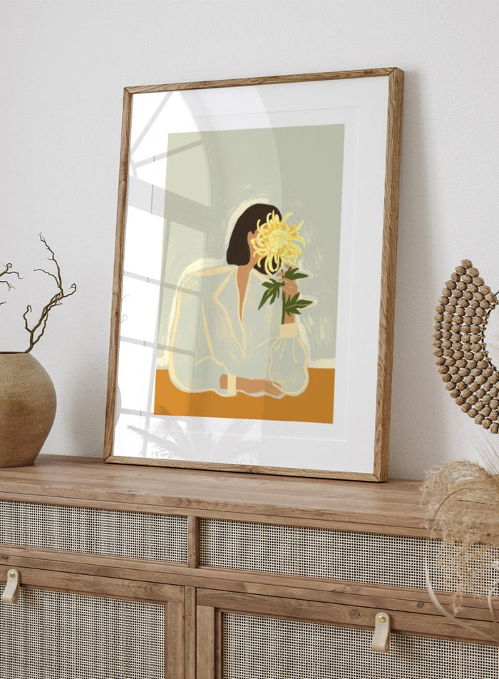 Illustration of a woman in a white dress holding a large yellow flower against a light background. The Chrysanthemum by Arty Guava is a modern portrait illustration featuring a woman with flowers, contemporary floral wall art style, and officially licensed artwork.