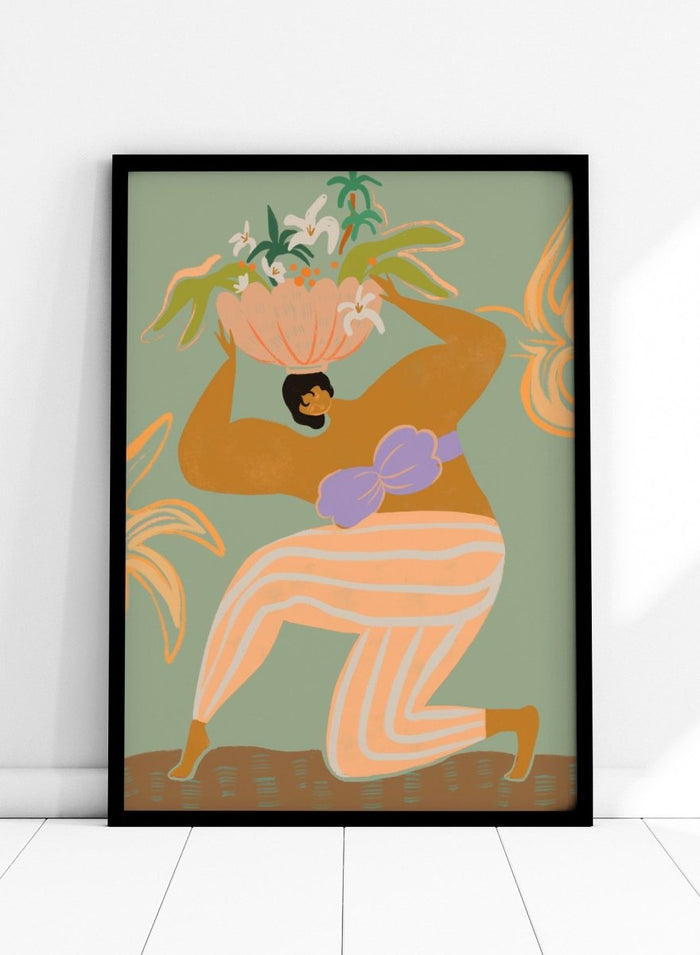 A stylized art print featuring a woman in flowing peach and white striped pants with a purple sash, carrying a large flower basket on her head against a muted sage green background. The Weight of the World by Arty Guava premium framed fine art print featuring a woman carrying tropical flowers in soft green, peach, and lilac tones.