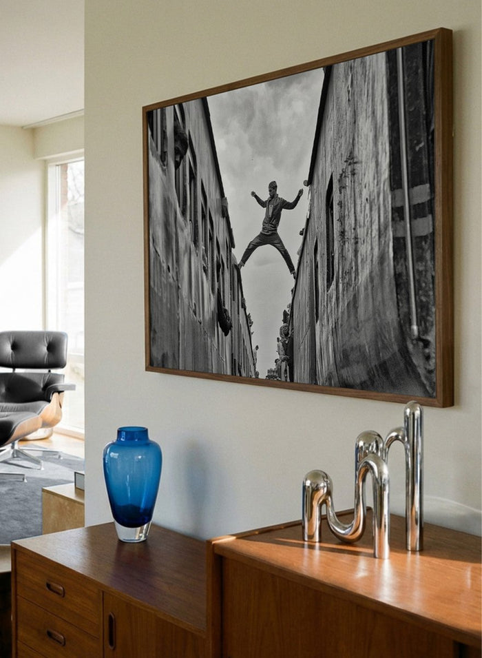 Superman by Azim Khan Ronnie black and white photography print of man jumping between trains in Bangladesh, urban action wall art poster