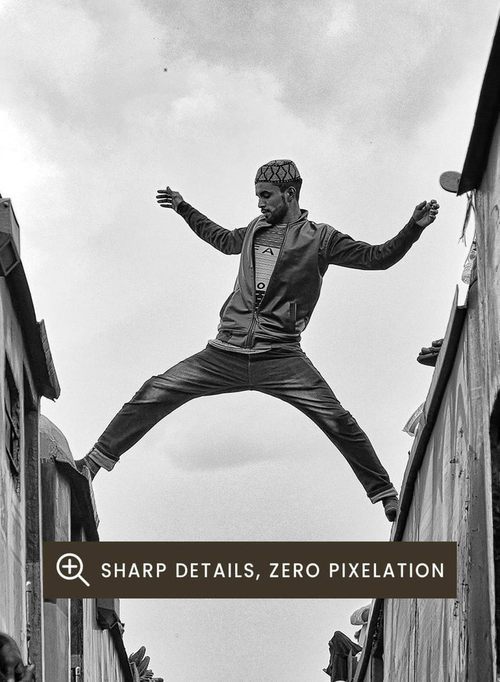 Superman by Azim Khan Ronnie black and white photography print of man jumping between trains in Bangladesh, urban action wall art poster