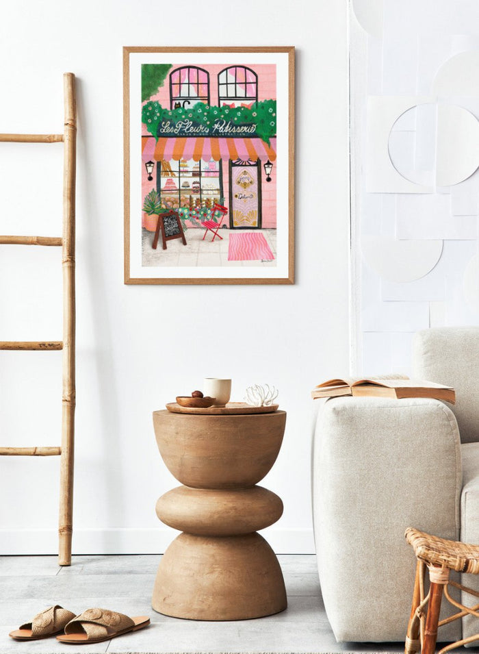 Illustration of a bakery named 'Les Fleuris Patisserie' with a pink exterior and greenery. Bake Shop Front by Baroo Bloom art print featuring a colorful bakery storefront illustration. Whimsical European street scene wall poster with pink tones and playful detail.