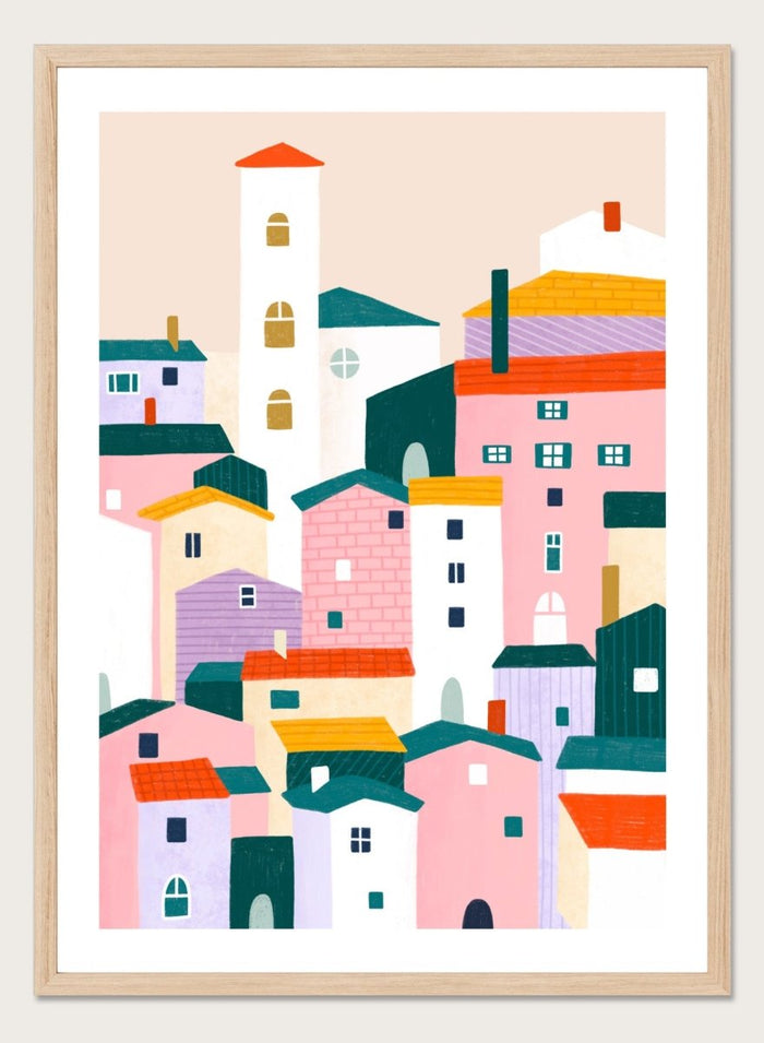 A framed minimalist art print depicting a cluster of stylized pastel houses and a church tower in pink, peach, teal, yellow, and cream tones. Charming Colorful Houses by Bea Müller premium framed fine art print featuring a playful town of pink, lavender, cream, and teal buildings.