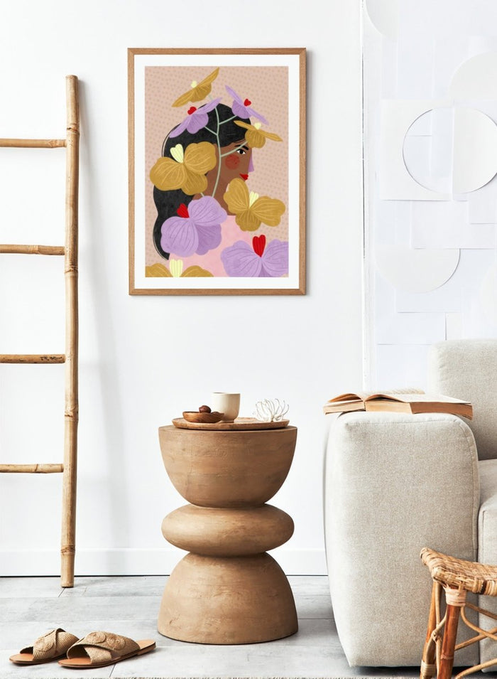 A framed art print featuring a stylized illustration of a woman with dark hair surrounded by large purple and yellow flowers on a beige patterned background. Floral Woman Portrait by Bea Müller premium framed fine art print featuring a woman surrounded by oversized lilac, mustard, and red flowers.