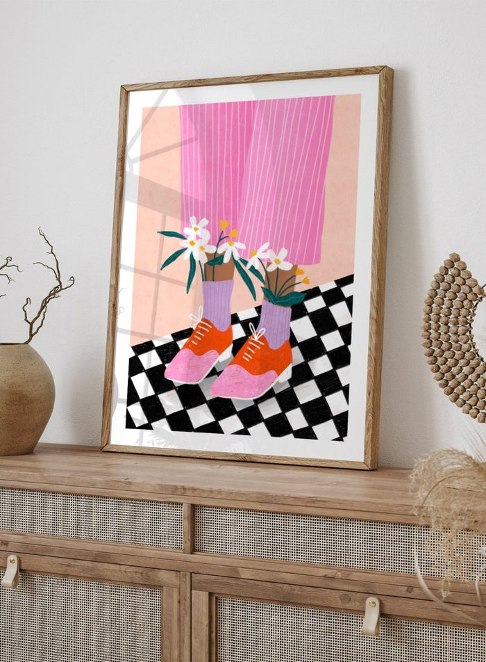 A stylized fashion illustration of a person's legs wearing pink pinstripe trousers, lavender socks, orange and pink shoes, and holding white flowers, set against a peach background with a black-and-white checkered floor. Flowering Oxford Style by Bea Müller premium framed fine art print featuring colorful Oxford shoes, lilac socks, and flowers on a checkered floor.