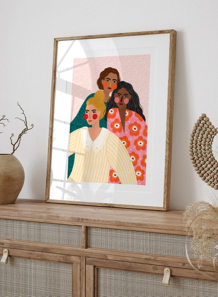 Illustration of three women with colorful clothing and patterns on a pink background. Girl Friends by Bea Müller is an officially licensed art print featuring three women illustrated in her signature bold colors and modern expressive style.