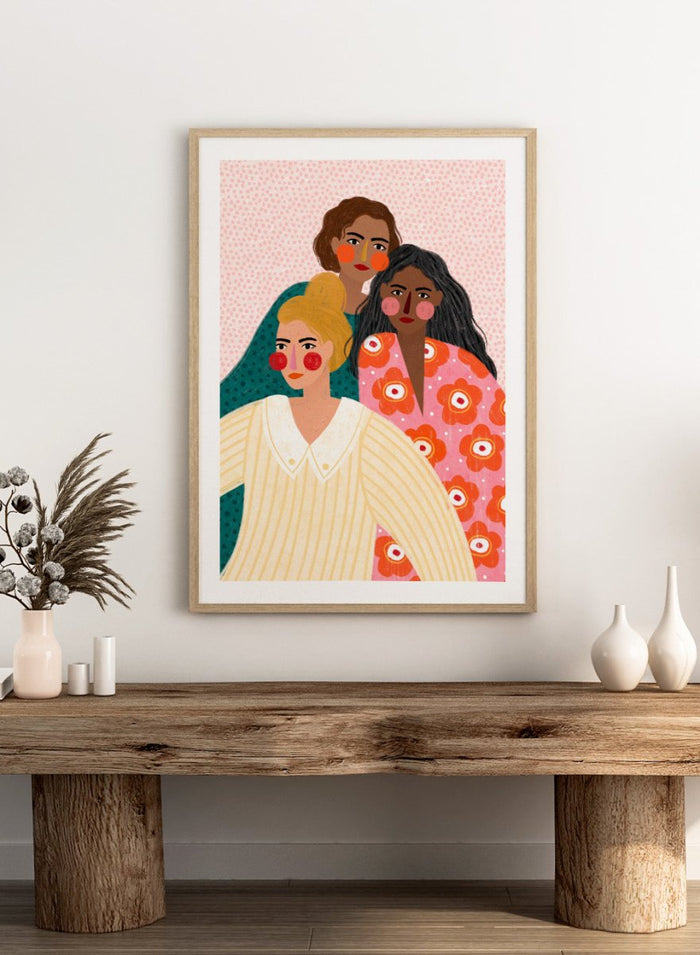 Illustration of three women with colorful clothing and patterns on a pink background. Girl Friends by Bea Müller is an officially licensed art print featuring three women illustrated in her signature bold colors and modern expressive style.