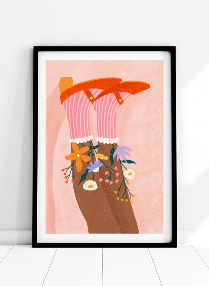 A stylized art print featuring a pair of legs wearing pink striped socks with white ruffles, decorated with colorful wildflowers, and topped with orange high-heeled shoes, set against a textured pink background. Happy Feet and Flowers by Bea Müller premium framed fine art print featuring red Mary Janes, striped socks, and colorful flowers on a soft pink background.