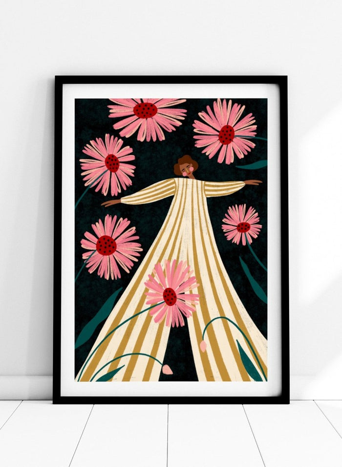 A framed art print featuring a stylized illustration of a woman in a cream and gold striped dress surrounded by large pink flowers on a dark background. Joyful Woman In Bloom by Bea Müller premium framed fine art print featuring a woman in a striped dress surrounded by oversized pink flowers.
