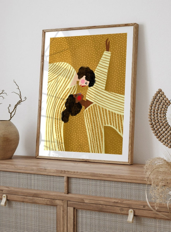 A framed art print featuring a stylized illustration of two women in cream and gold striped dresses against a textured gold background. Loving Embrace by Bea Müller premium fine art print featuring two figures in striped clothing, with warm colors and a bold, intimate composition.