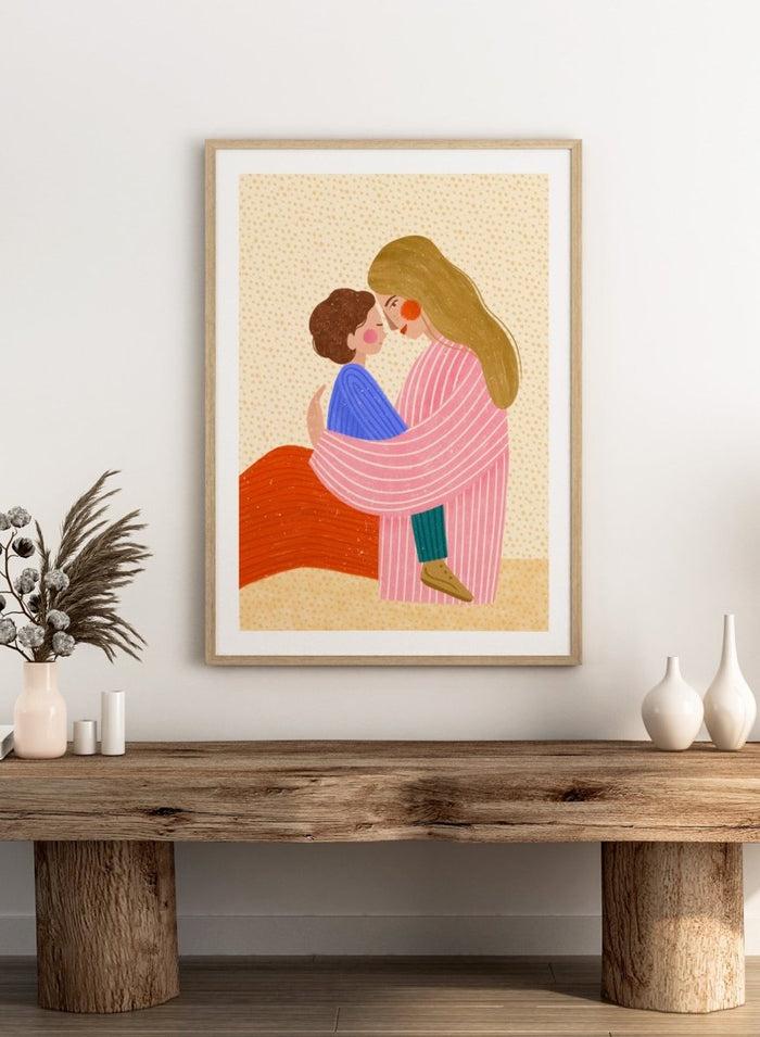 A framed art print featuring a stylized illustration of a woman in a pink striped robe embracing a child in a blue sweater. Loving Mother Child Embrace by Bea Müller premium framed fine art print featuring a mother holding her child close in warm, colorful tones.