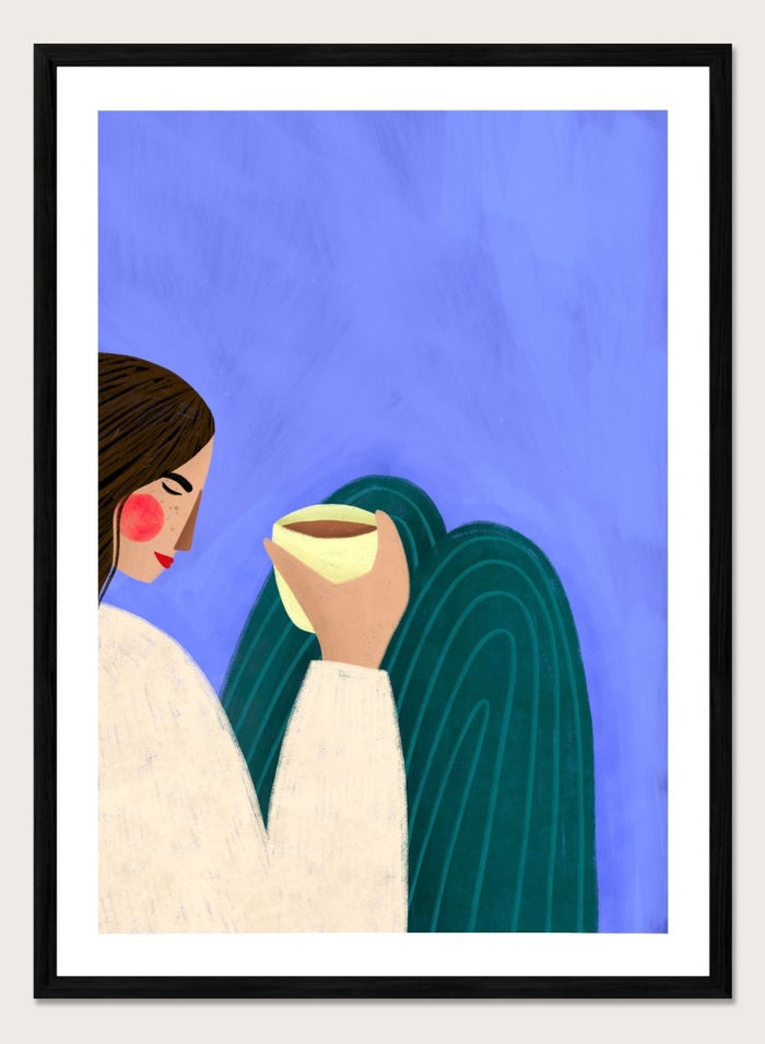 A framed minimalist art print featuring a stylized woman in profile with brown hair, a cream sweater, and a dark teal cape against a textured blue background, holding a pale yellow cup. Peaceful Coffee Moment by Bea Müller premium framed fine art print featuring a woman curled up with a warm drink in soft blue, cream, and teal tones.