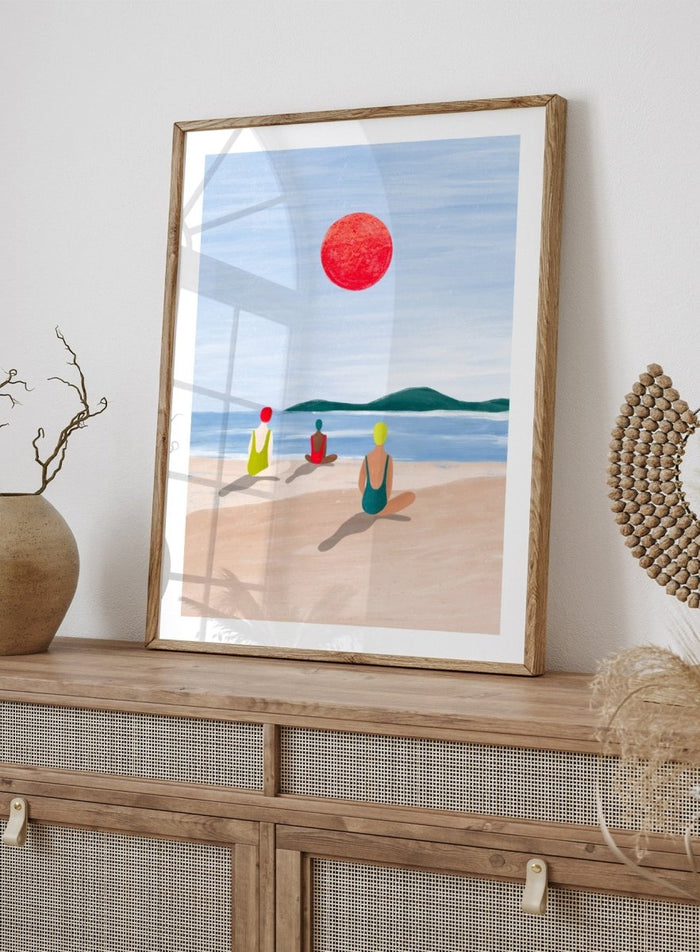 A minimalist art print depicting three figures meditating on a sandy beach under a large red sun. Red Sun Beach Serenity by Bea Müller premium fine art print featuring three figures on a beach beneath a bold red sun in a calm coastal setting.