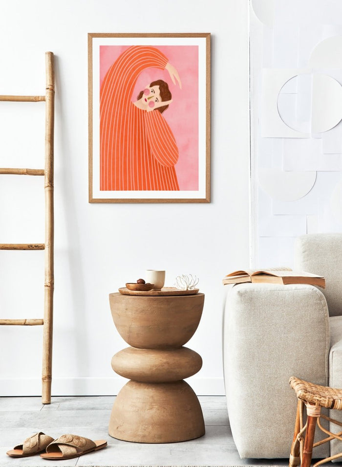 A framed art print featuring a stylized illustration of a woman in a flowing orange and white striped dress, posed in a graceful arch against a soft pink background. Thoughtful Girl in Stripes by Bea Müller premium framed fine art print featuring a woman in an oversized orange striped top against a soft pink background.