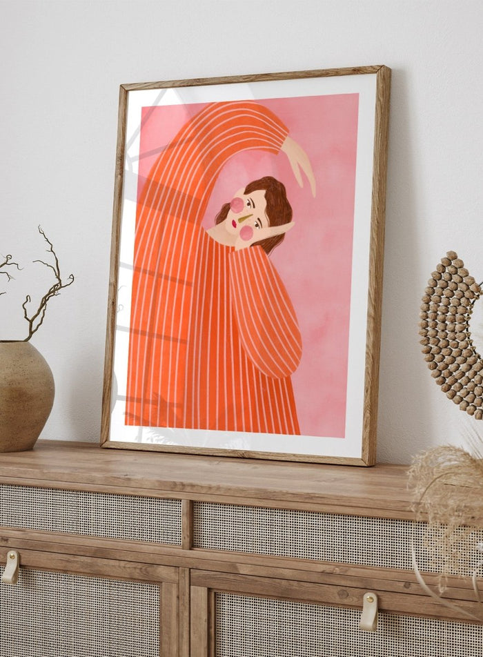 A framed art print featuring a stylized illustration of a woman in a flowing orange and white striped dress, posed in a graceful arch against a soft pink background. Thoughtful Girl in Stripes by Bea Müller premium framed fine art print featuring a woman in an oversized orange striped top against a soft pink background.
