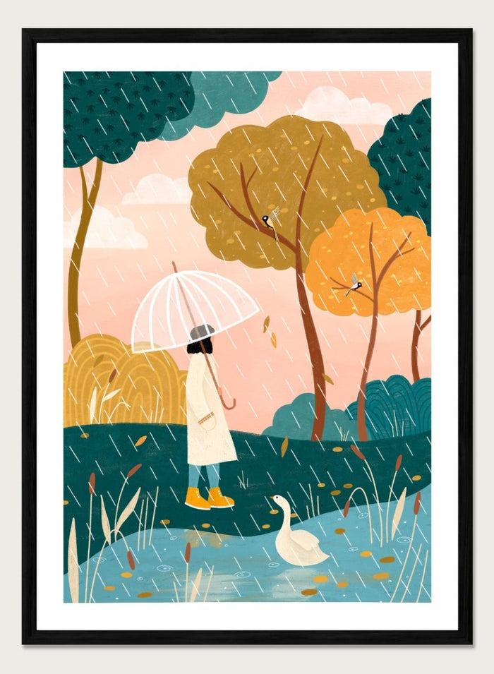 A framed art print featuring a whimsical illustration of a person holding a clear umbrella in the rain near a pond with a white goose, surrounded by stylized trees in teal, mustard, and orange tones. Walking In Autumn Rain by Bea Müller premium framed fine art print featuring a woman with an umbrella beside a pond in a colorful rainy landscape.