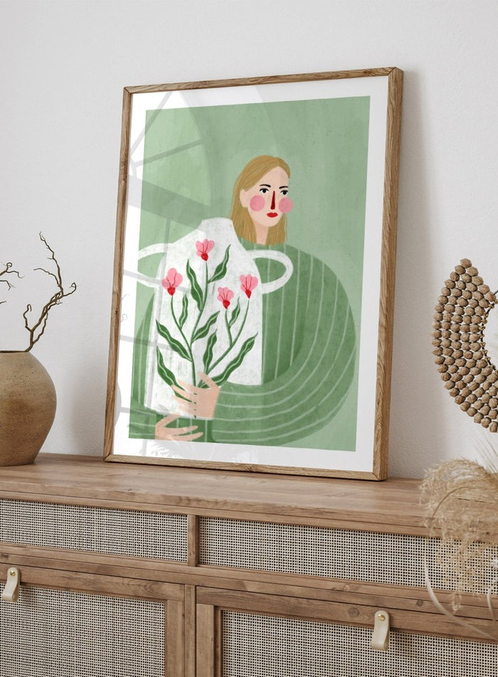 A framed art print featuring a stylized illustration of a woman with blonde hair holding a white apron decorated with pink flowers and green leaves, set against a sage green background. Woman Holding Flowers by Bea Müller premium framed fine art print featuring a woman carrying a white vase filled with pink flowers and green leaves.