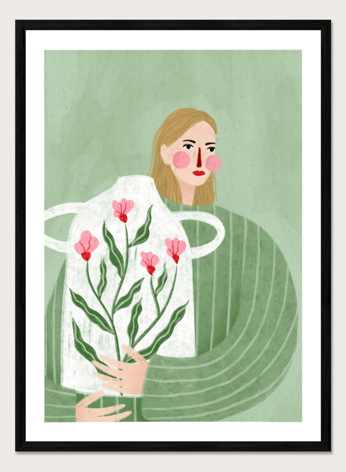 A framed art print featuring a stylized illustration of a woman with blonde hair holding a white apron decorated with pink flowers and green leaves, set against a sage green background. Woman Holding Flowers by Bea Müller premium framed fine art print featuring a woman carrying a white vase filled with pink flowers and green leaves.