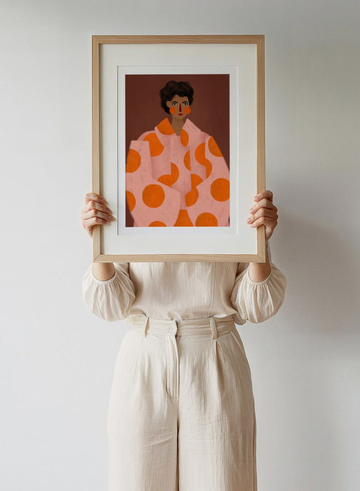 Woman With Orange Dots by Bea Müller is an officially licensed art print featuring a bold modern portrait with graphic color and pattern. Available framed or unframed.