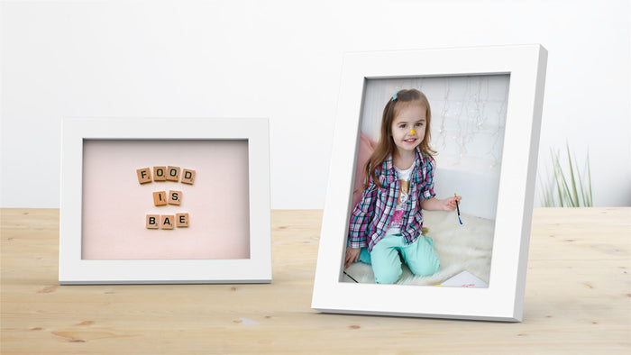 Two Blok Range white picture and poster frames showcasing a playful child and artistic message.