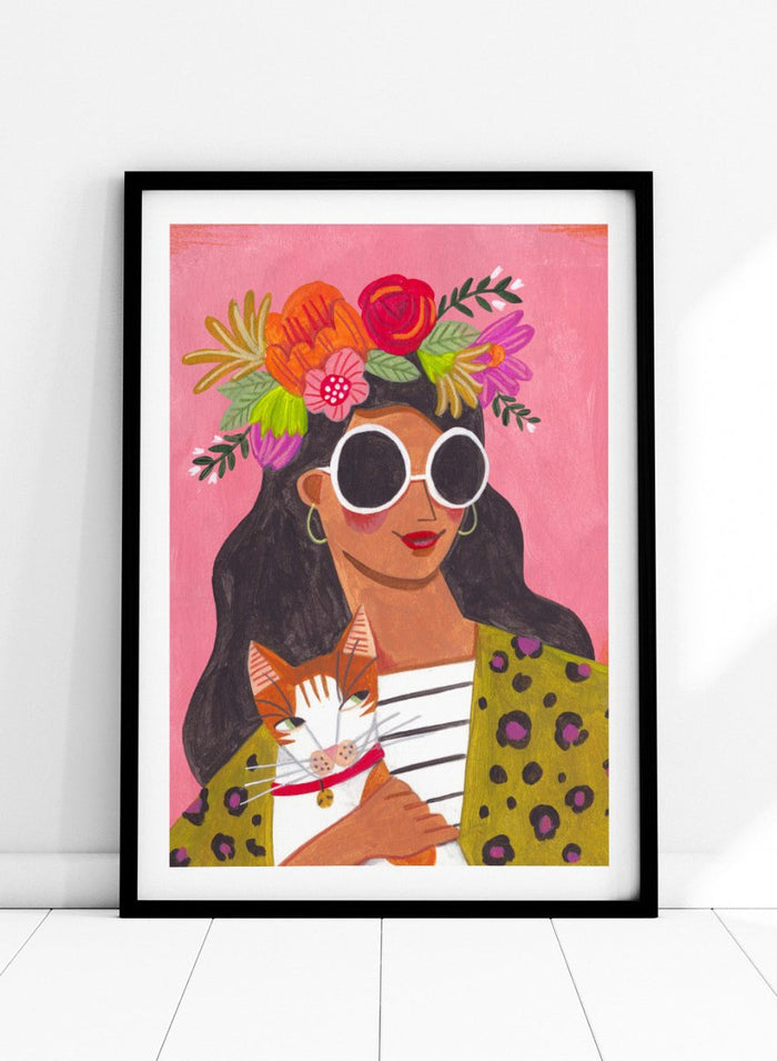 Illustration of a woman with a floral headpiece and sunglasses on a pink background. Cat Lady by Caroline Bonne Müller is a fine art print and wall poster of a woman holding a cat with bold color, floral crown, and modern aesthetic style.