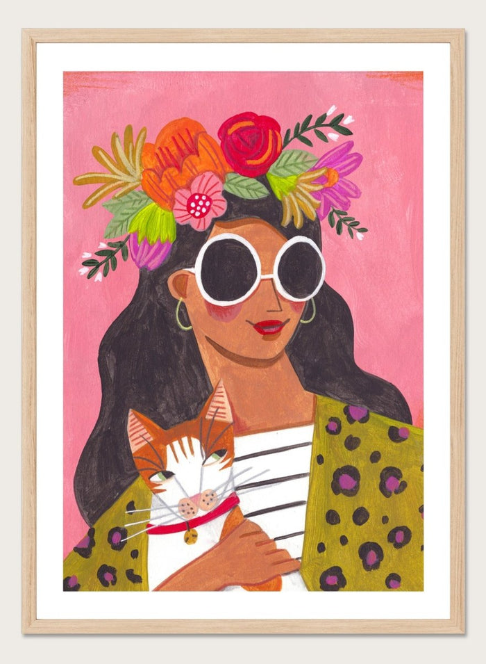 Illustration of a woman with a floral headpiece and sunglasses on a pink background. Cat Lady by Caroline Bonne Müller is a fine art print and wall poster of a woman holding a cat with bold color, floral crown, and modern aesthetic style.
