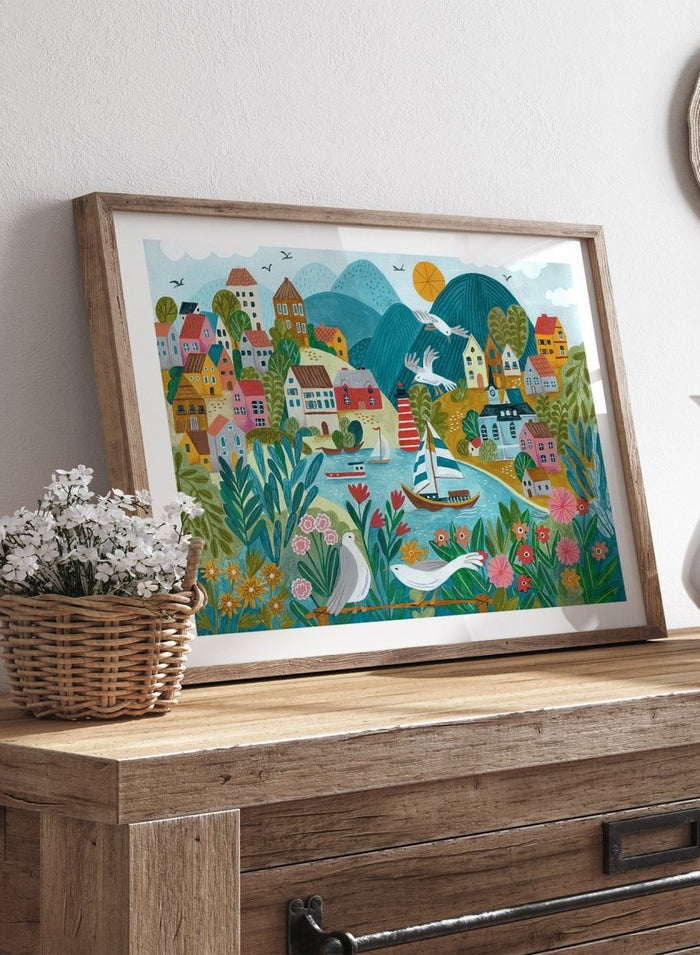 Coastal Village by Caroline Bonne Müller is a colorful coastal town art print with boats, lighthouse, and floral foreground in modern aesthetic illustration style.