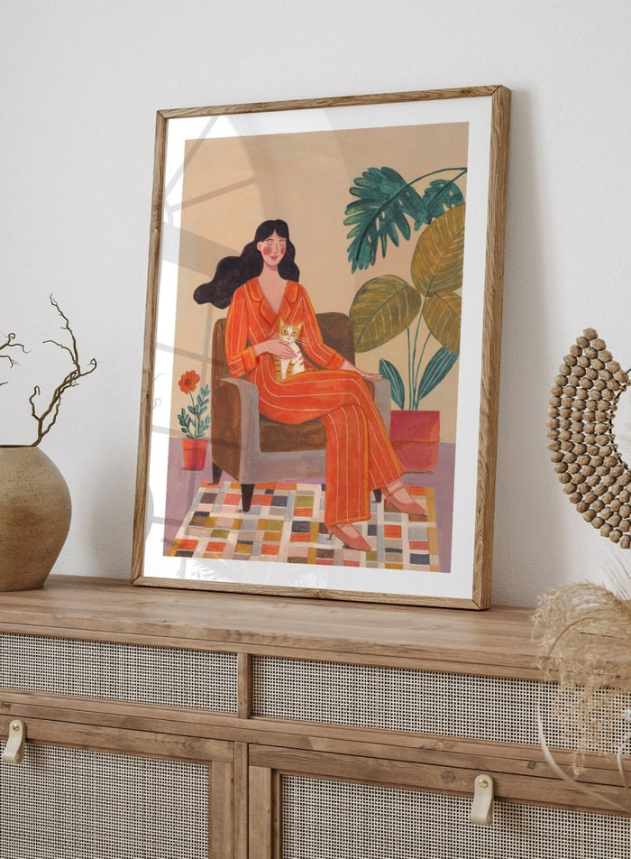 Illustration of a woman in an orange outfit sitting in a chair with plants around her. Cozy Home with Cat by Caroline Bonne Müller is a fine art print and wall poster featuring a woman in an orange outfit sitting with a cat in a warm, plant-filled interior.