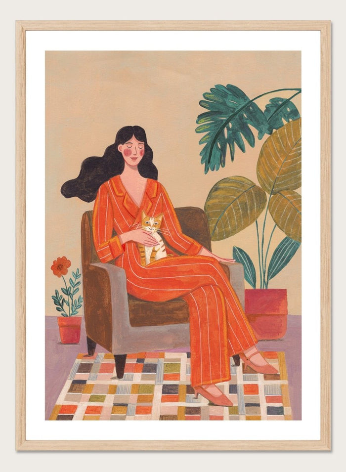 Illustration of a woman in an orange outfit sitting in a chair with plants around her. Cozy Home with Cat by Caroline Bonne Müller is a fine art print and wall poster featuring a woman in an orange outfit sitting with a cat in a warm, plant-filled interior.