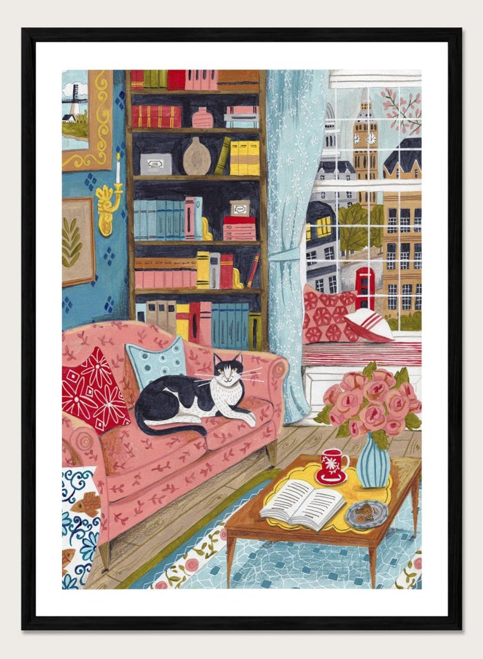 Illustration of a cozy living room with a cat on a pink sofa, bookshelf, and coffee table. Cozy London Cat by Caroline Bonne Müller is a fine art print and wall poster featuring a cat lounging in a colorful living room with a London city view.