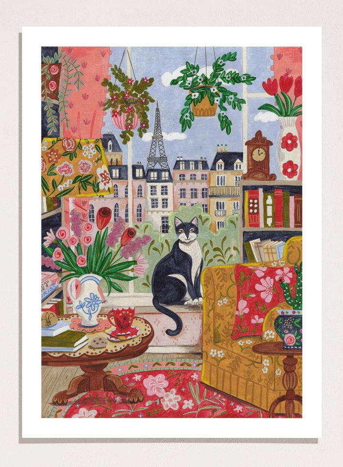 Colorful illustration of a living room with a cat, flowers, and a cityscape. Cozy Parisian Window Cat by Caroline Bonne Müller is a fine art print and wall poster of a cat by a window with Paris view and colorful interior.