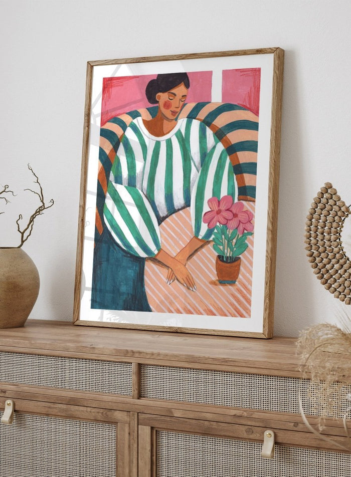 Artistic illustration of a person holding a potted plant with a colorful background. Peaceful Woman Home by Caroline Bonne Müller is a fine art print and wall poster of a woman seated indoors with flowers and striped patterns.
