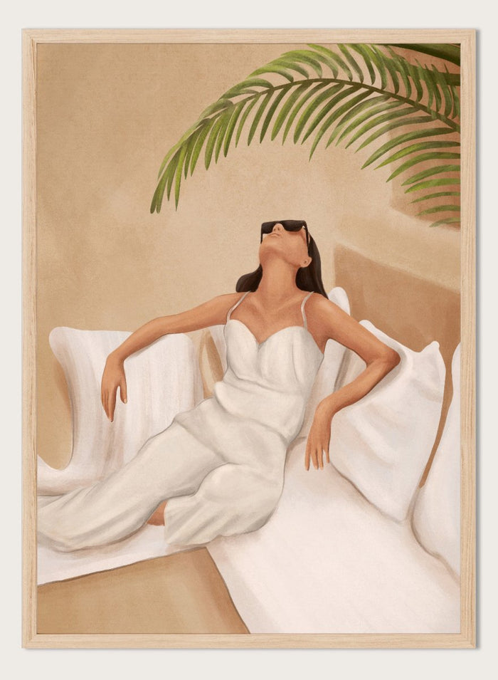 Woman in a white dress lying on a couch with a palm leaf above, against a beige wall. Chic Summer Serenity by City Art features a woman reclining among cushions and palm leaves, bringing warm summer tones and relaxed interiors to your home.